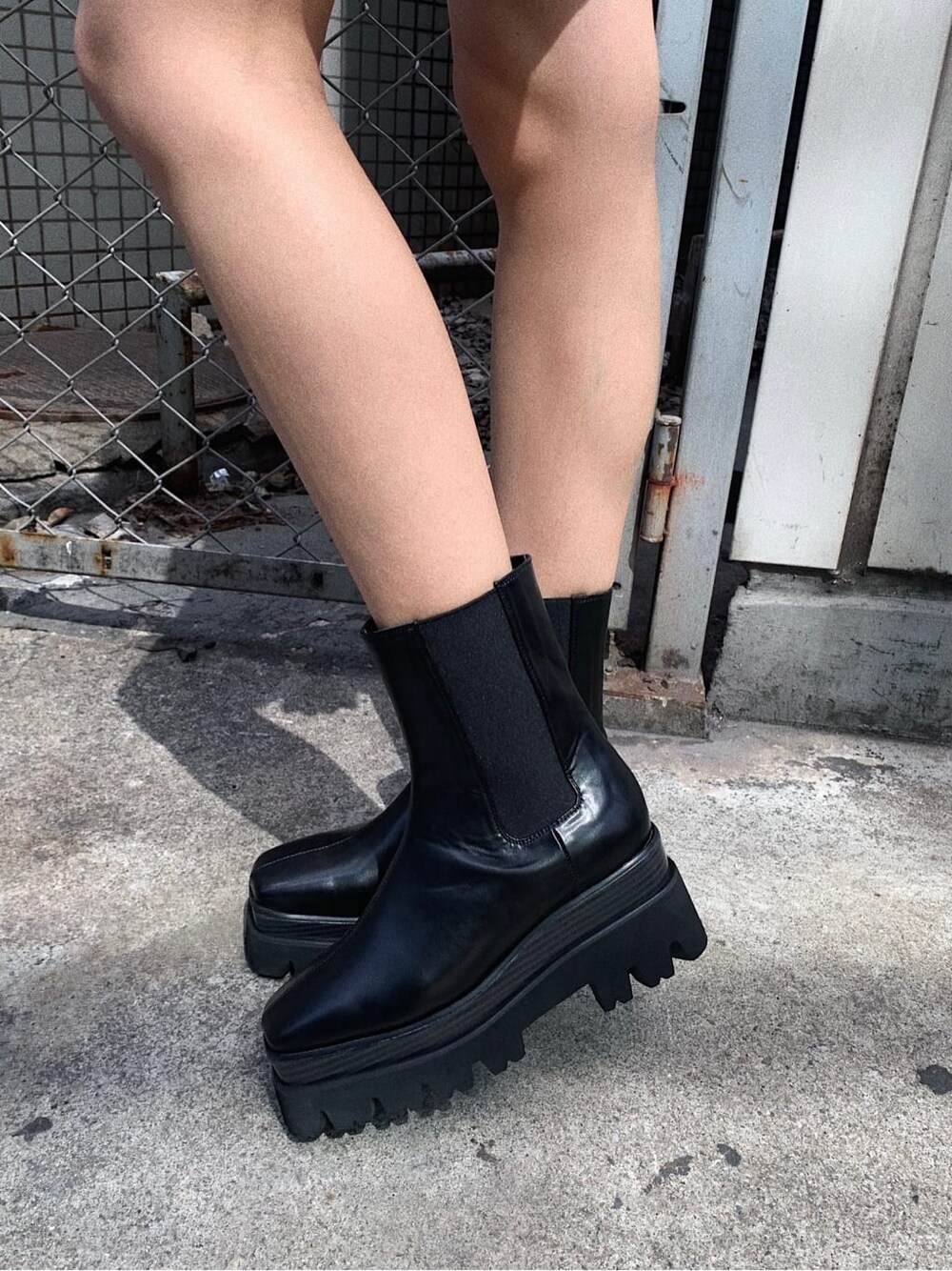 ブラック系のショルダーバッグ、ホワイト系のスカート、パープル系のニット/セーターを着用したレディースの春コーディネートの9枚目の写真