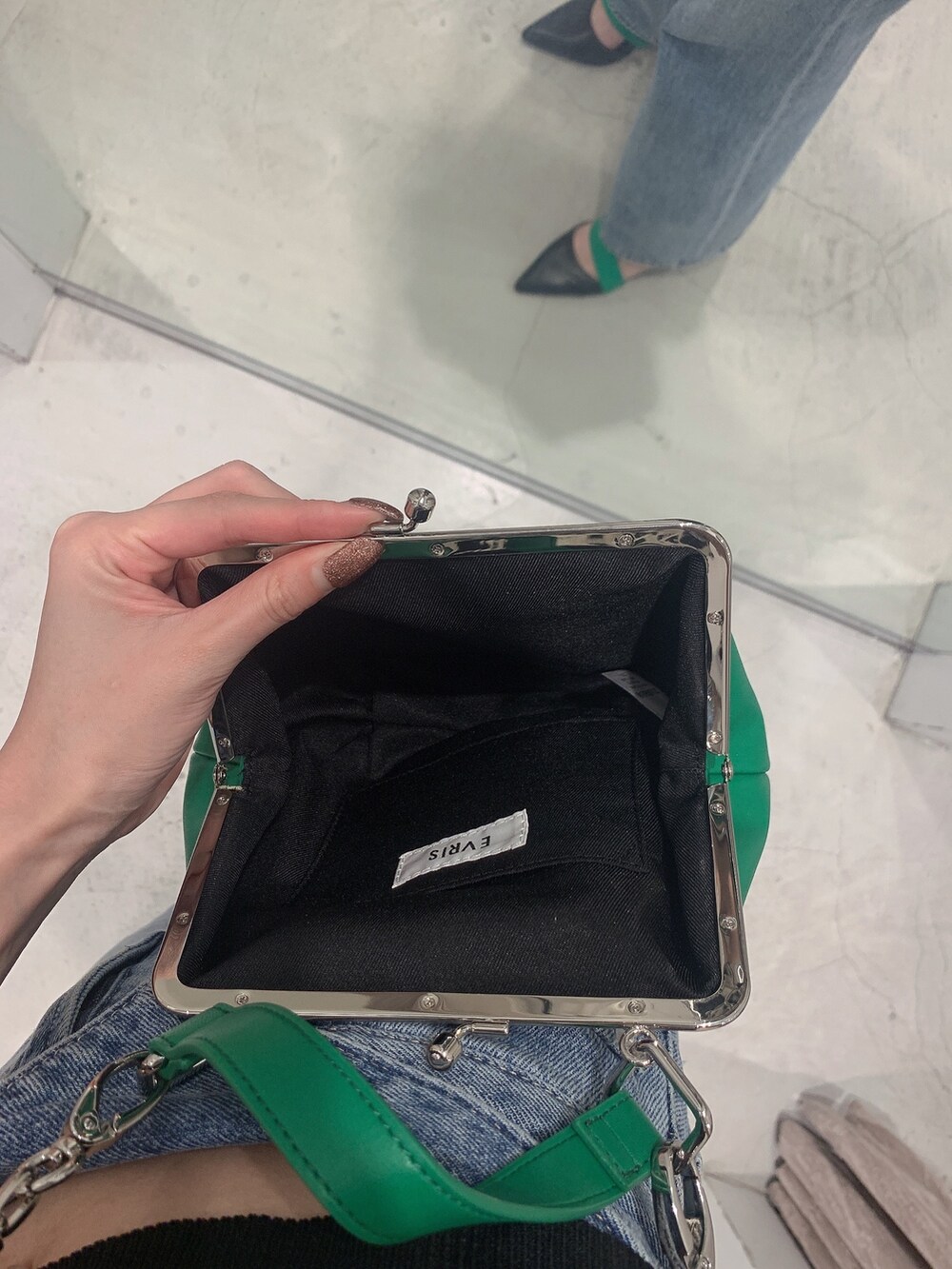 グリーン系のショルダーバッグ、ブルー系のデニムパンツ、ブラック系のニット/セーターを着用したレディースの春コーディネートの9枚目の写真