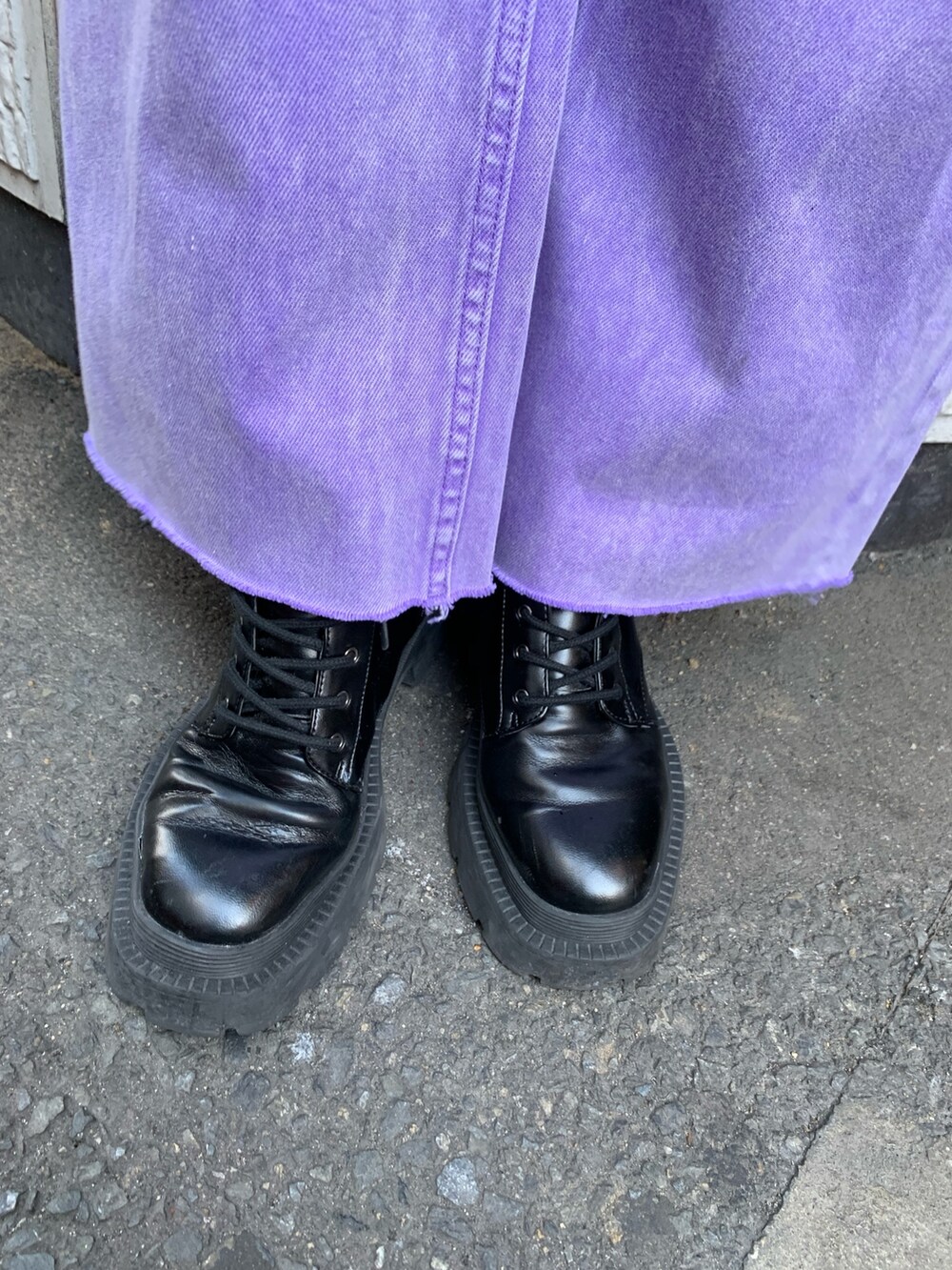 パープル系のデニムパンツ、ブラック系のニット/セーター、ブラック系のハンドバッグを着用したレディースの冬コーディネートの9枚目の写真