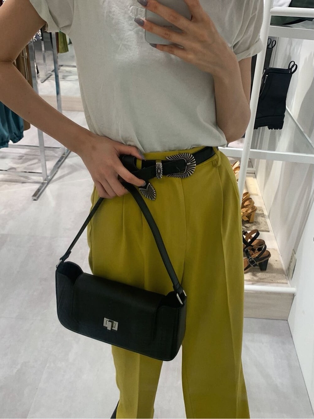 イエロー系のスラックス、ホワイト系のTシャツ/カットソー、ブラック系のブーツを着用したレディースの春コーディネートの6枚目の写真