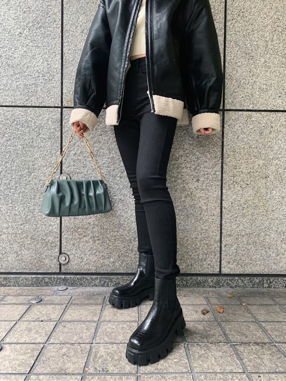 ブラック系のデニムパンツ、ブラック系のブルゾン、その他のブーツを着用したレディースの冬コーディネートの5枚目の写真