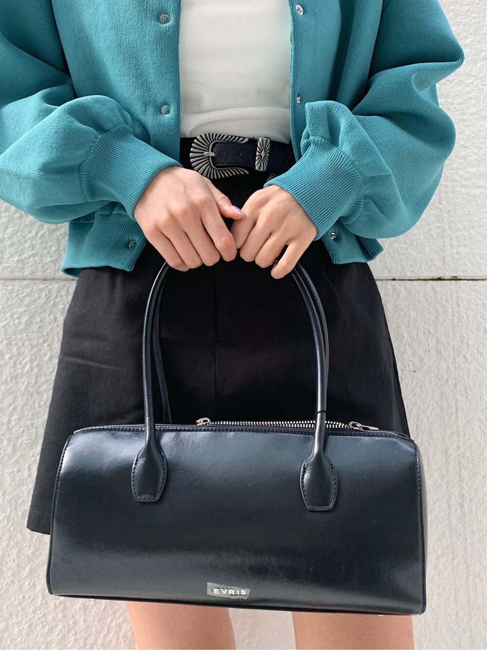 ブラック系のブーツ、ブラック系のスカート、ホワイト系のキャミソールを着用したレディースの冬コーディネートの8枚目の写真