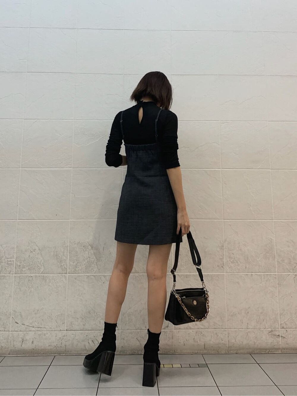 ブラック系のショルダーバッグ、ブラック系のTシャツ/カットソー、グレー系のワンピースを着用したレディースの秋コーディネートの2枚目の写真