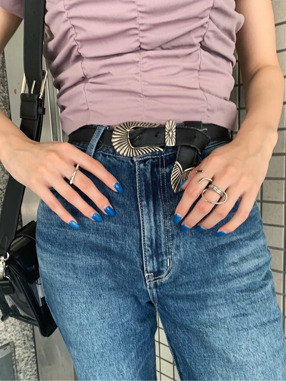 ブルー系のデニムパンツ、ブラック系のサンダル、ブラック系のベルトを着用したレディースの夏コーディネートの9枚目の写真