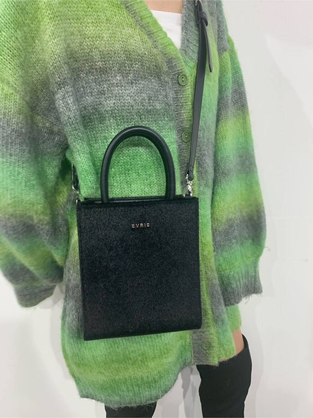 グリーン系のカーディガン/ボレロ、ブラック系のブーツ、ブラック系のショルダーバッグを着用したレディースの秋コーディネートの8枚目の写真