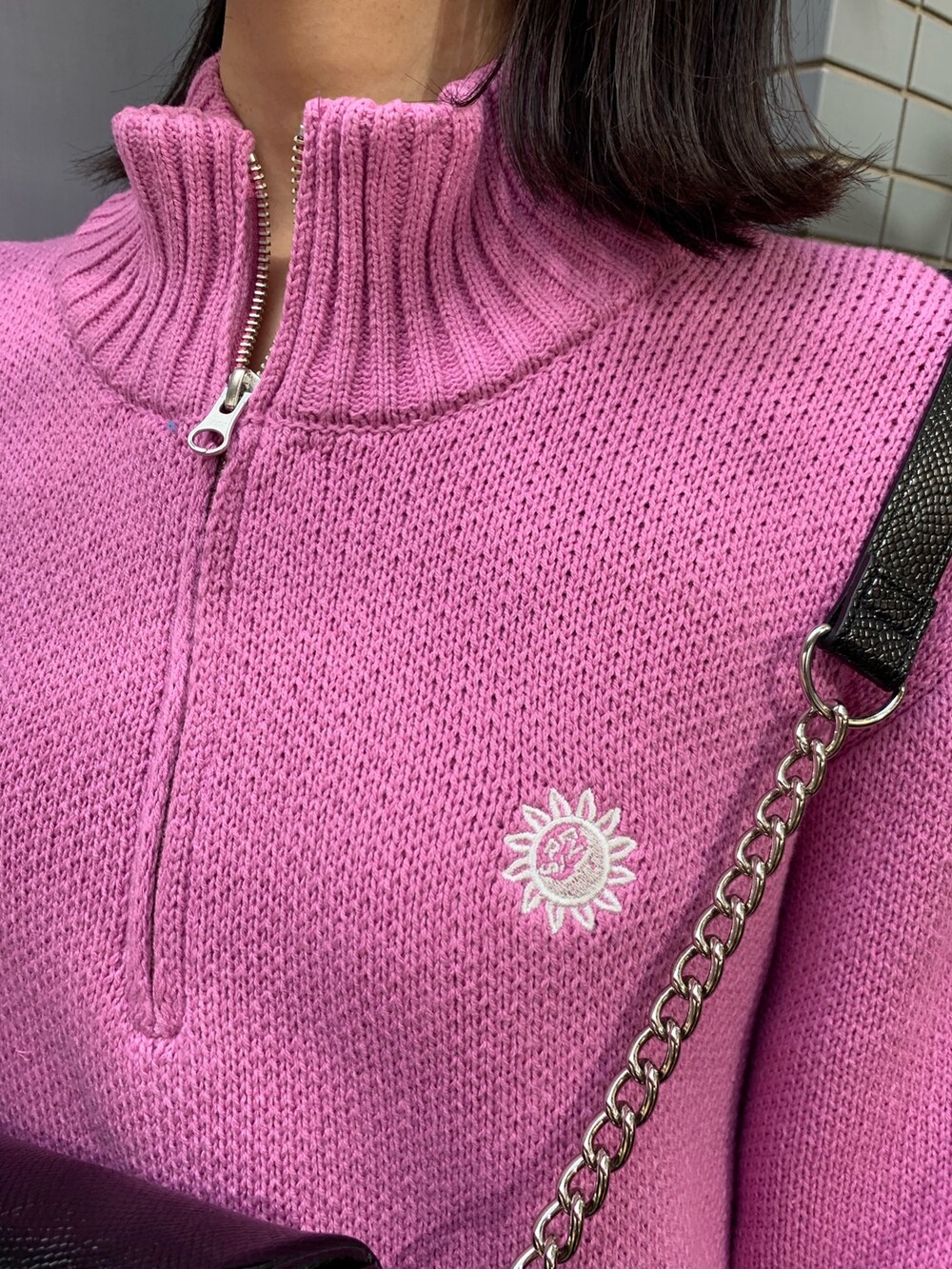 ピンク系のニット/セーター、ブラック系のブーツ、ブラック系のボディバッグ/ウエストポーチを着用したレディースの冬コーディネートの4枚目の写真