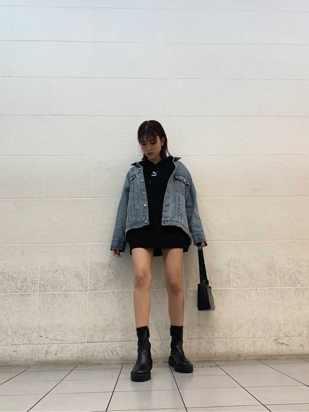 ブルー系のデニムジャケット、ブラック系のスカート、ブラック系のショルダーバッグを着用したレディースの春コーディネートの3枚目の写真