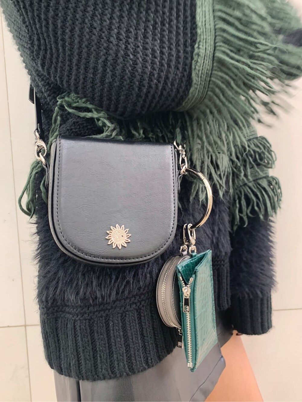 ブラック系のショルダーバッグ、ブラック系のブーツ、ブラック系のスカートを着用したレディースの冬コーディネートの6枚目の写真