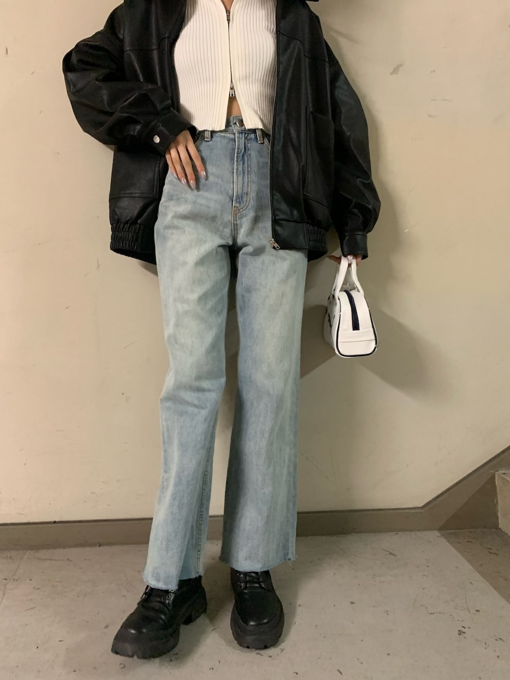 ホワイト系のニット/セーター、ブラック系のブルゾン、ブルー系のデニムパンツを着用したレディースの秋コーディネートの6枚目の写真