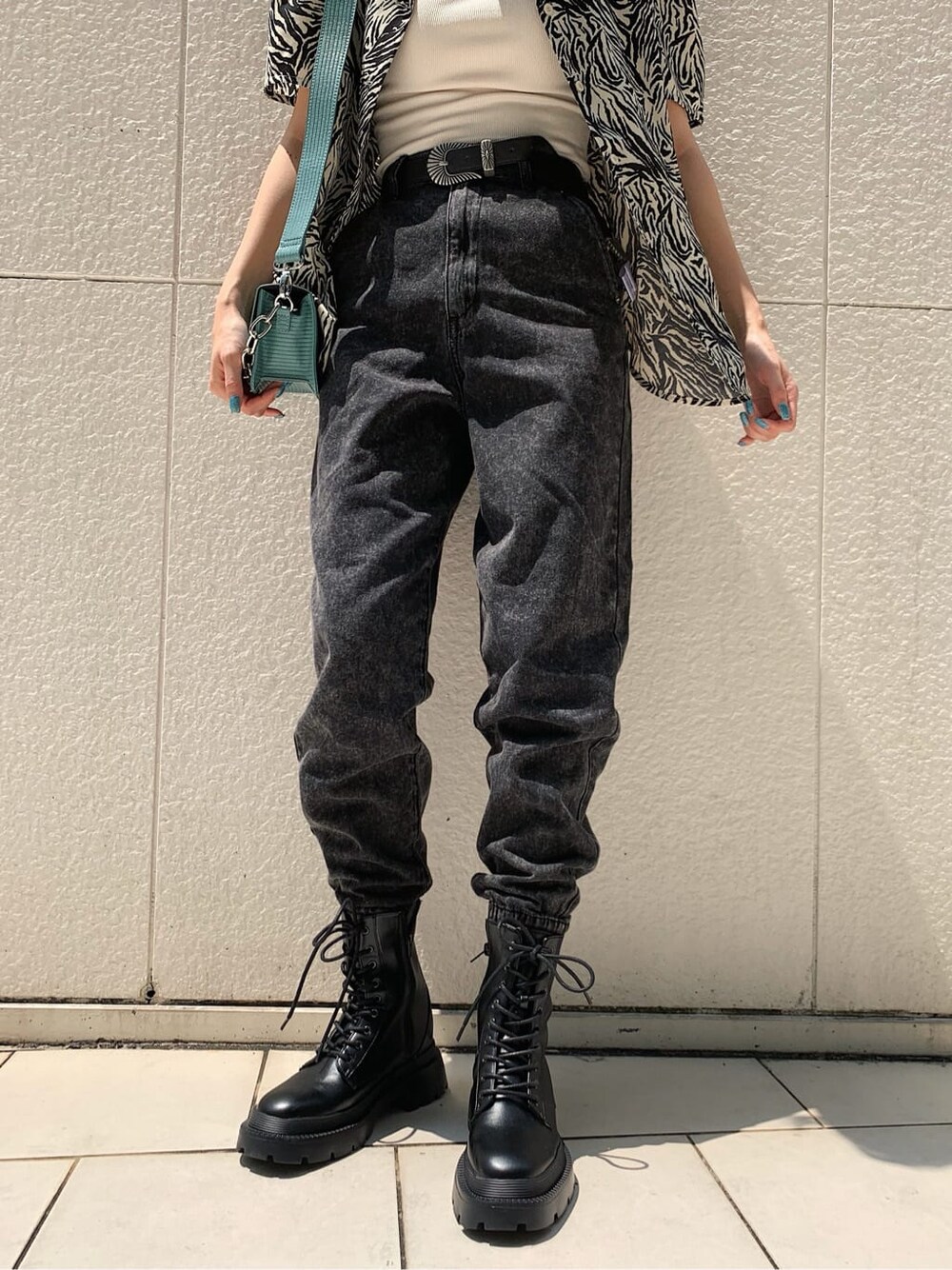 ブラック系のブーツ、ブラック系のデニムパンツ、ホワイト系のシャツ/ブラウスを着用したレディースの夏コーディネートの7枚目の写真