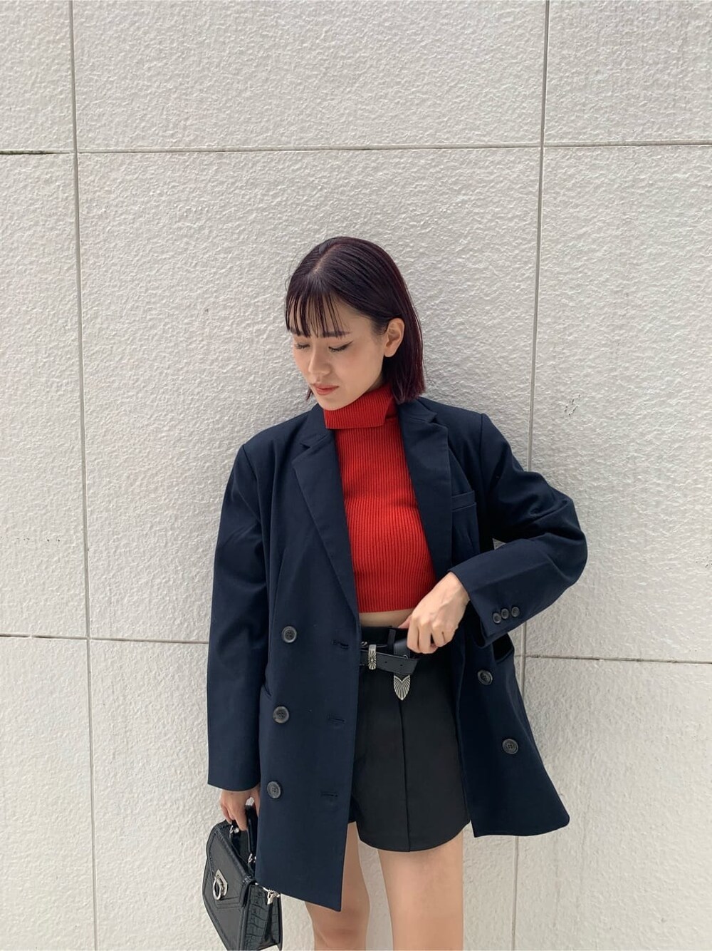 ブルー系のテーラードジャケット、ブラック系のハンドバッグ、ブラック系のブーツを着用したレディースの秋コーディネートの4枚目の写真