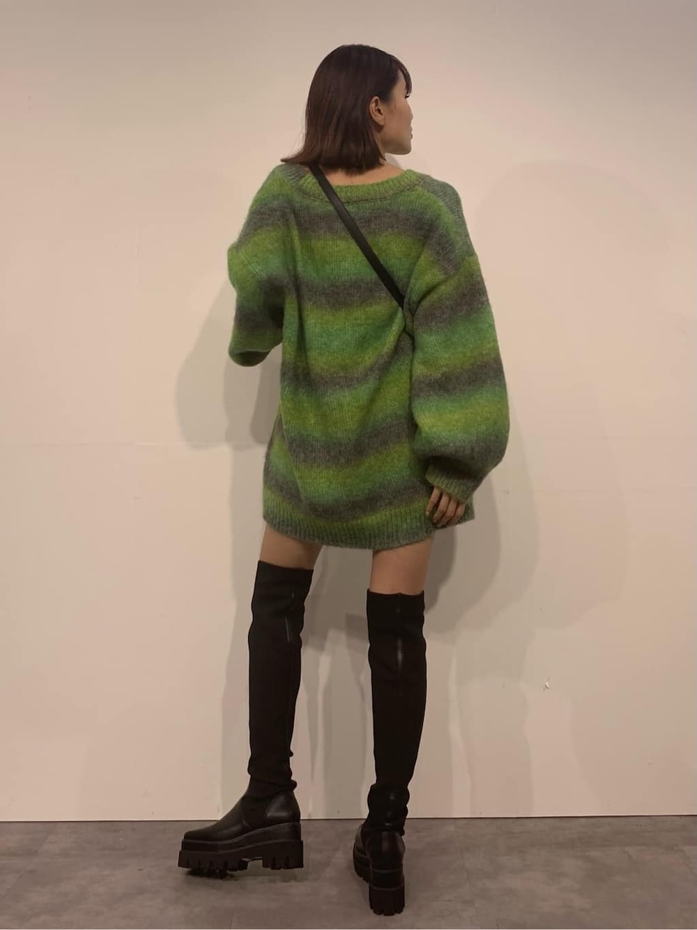 グリーン系のカーディガン/ボレロ、ブラック系のブーツ、ブラック系のショルダーバッグを着用したレディースの秋コーディネートの3枚目の写真