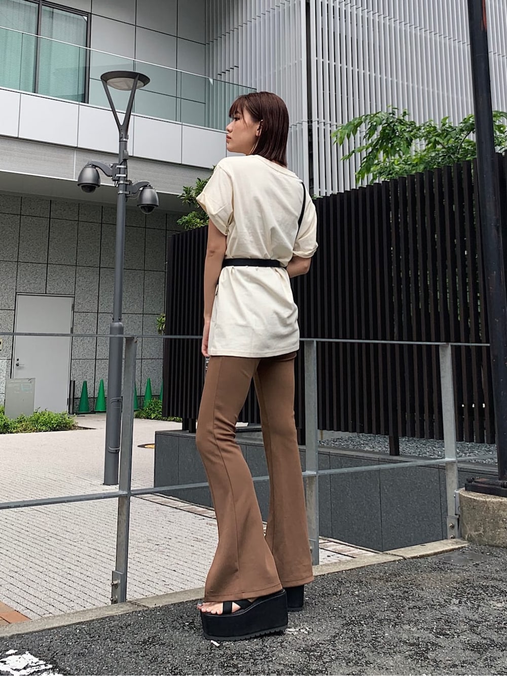 ブラック系のサンダル、ホワイト系のTシャツ/カットソー、ブラック系のベルトを着用したレディースの夏コーディネートの2枚目の写真