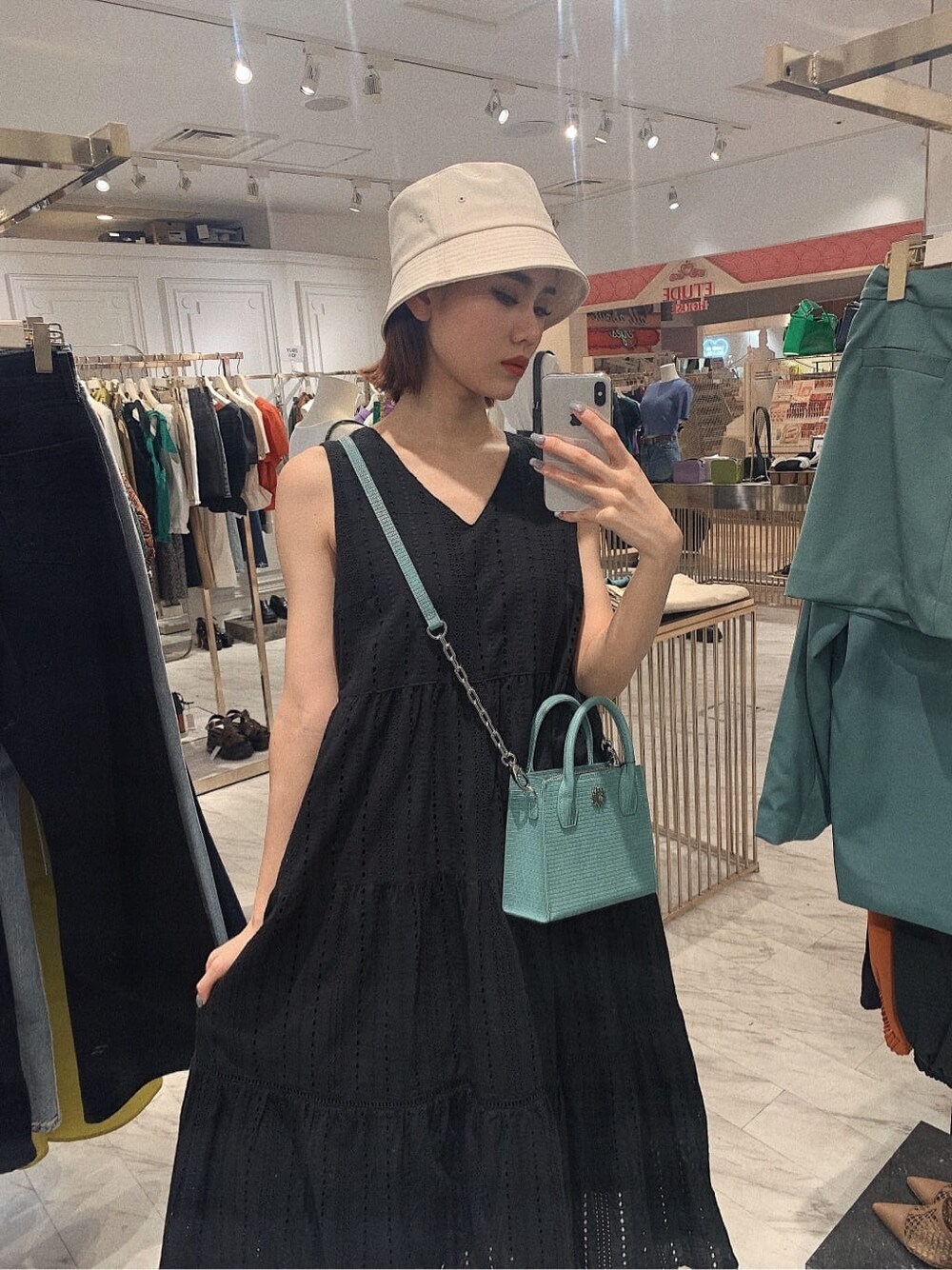 ブラック系のサンダル、ブラック系のワンピース、ブルー系のショルダーバッグを着用したレディースの春コーディネートの2枚目の写真