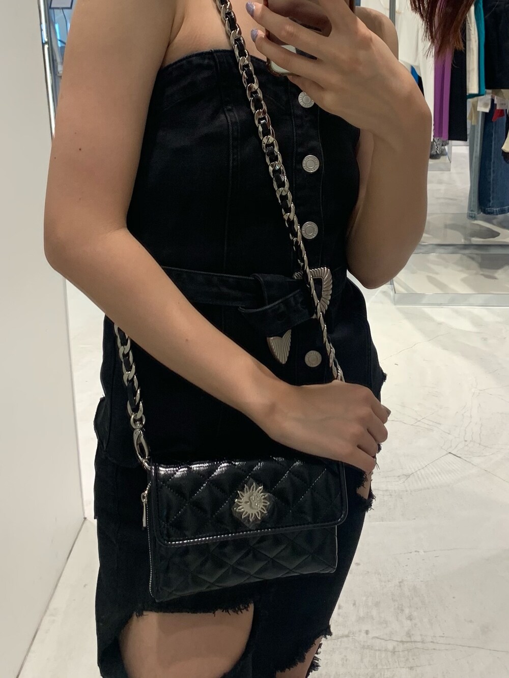 ブラック系のチューブトップ、ブラック系のデニムパンツ、ブラック系のショルダーバッグを着用したレディースの夏コーディネートの4枚目の写真