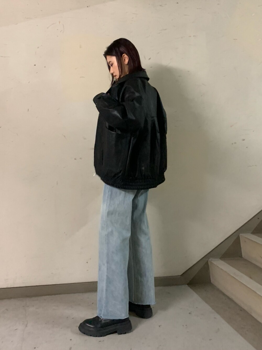 ホワイト系のニット/セーター、ブラック系のブルゾン、ブルー系のデニムパンツを着用したレディースの秋コーディネートの2枚目の写真