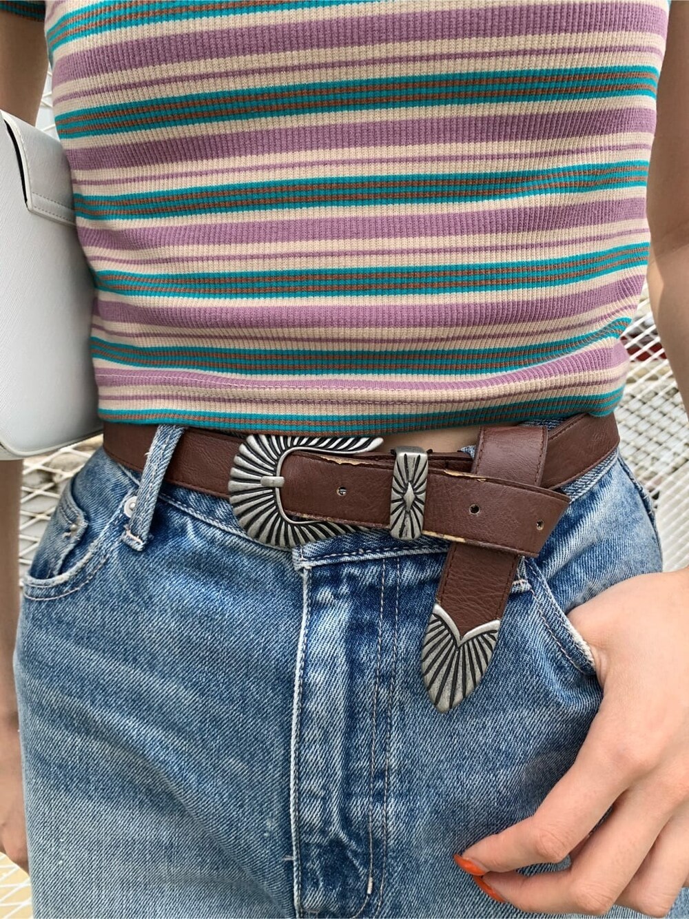 ブラウン系のサンダル、ブルー系のデニムパンツ、ホワイト系のショルダーバッグを着用したレディースの夏コーディネートの7枚目の写真