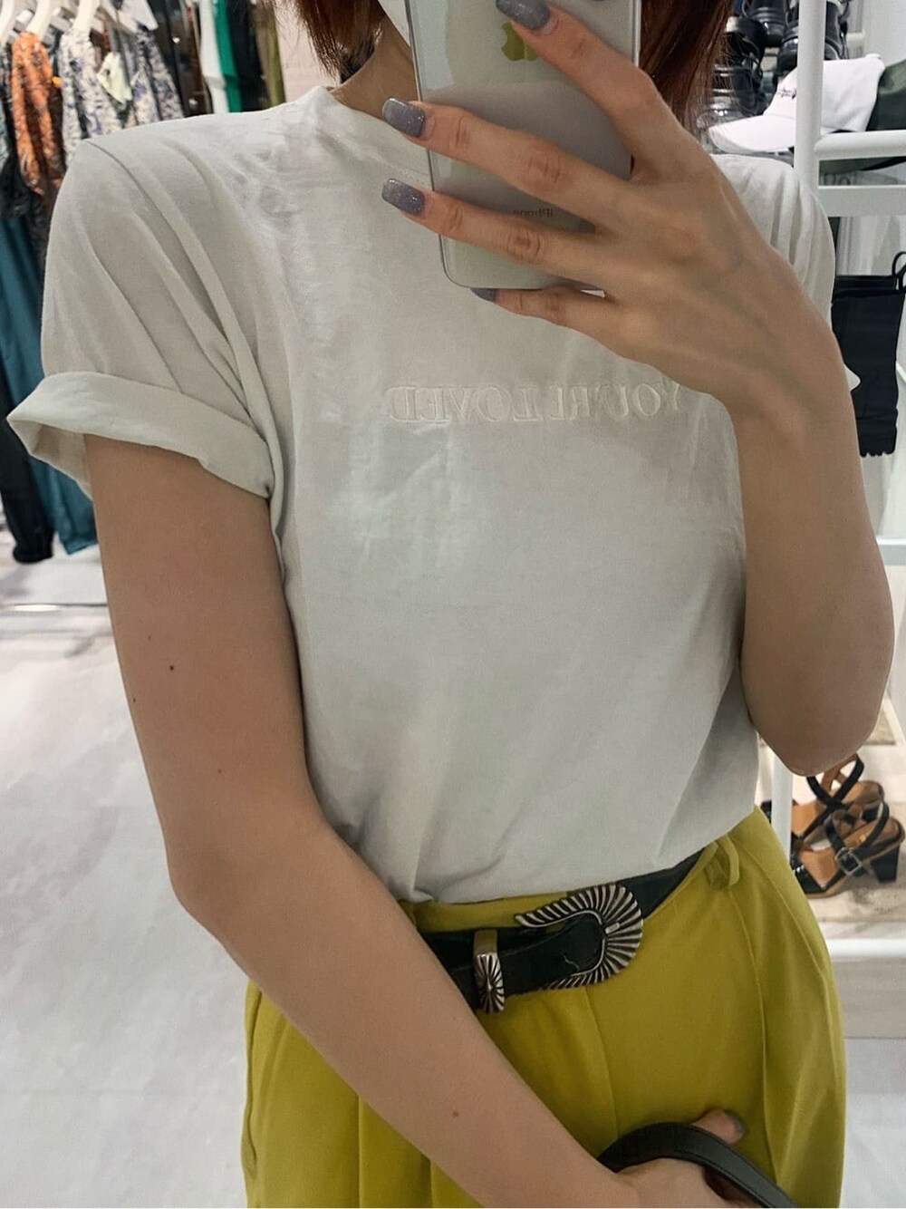 イエロー系のスラックス、ホワイト系のTシャツ/カットソー、ブラック系のブーツを着用したレディースの春コーディネートの4枚目の写真