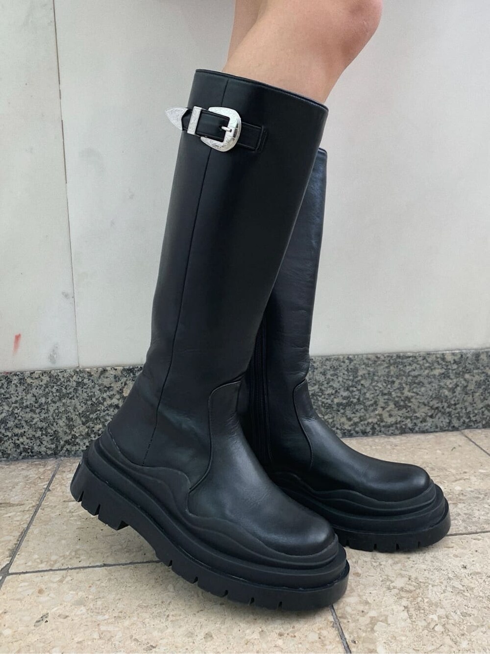 ブラック系のショルダーバッグ、ブラック系のブーツ、ブラック系のスカートを着用したレディースの冬コーディネートの7枚目の写真