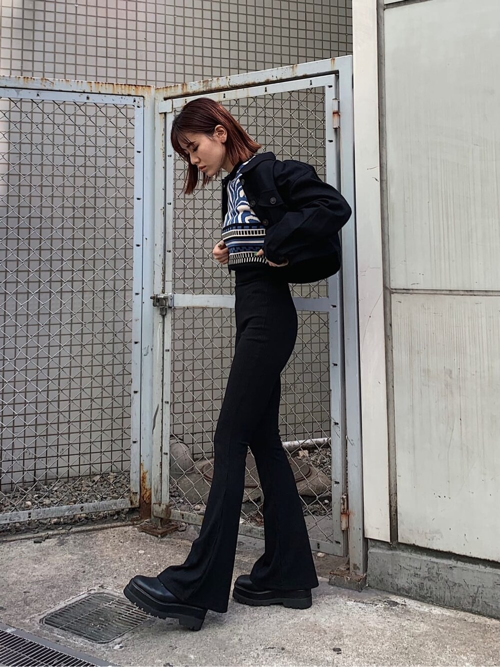 ブラック系のその他パンツ、ブラック系のブーツ、ブルー系のニット/セーターを着用したレディースの春コーディネートの2枚目の写真