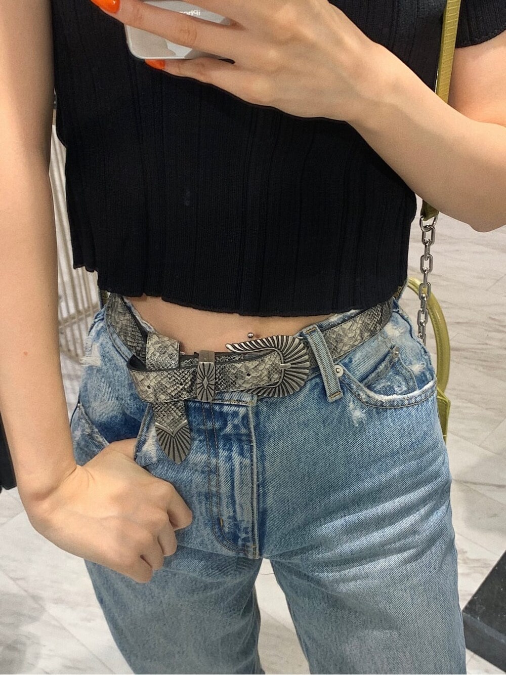 ブラック系のブーツ、ブラック系のニット/セーター、イエロー系のショルダーバッグを着用したレディースの春コーディネートの6枚目の写真