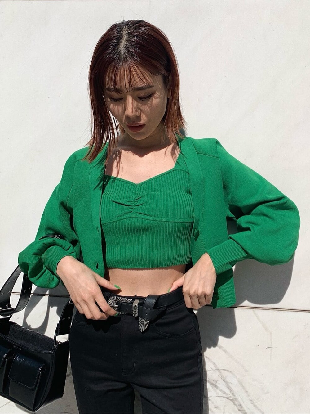 ブラック系のデニムパンツ、ブラック系のローファー、ブラック系のショルダーバッグを着用したレディースの春コーディネートの4枚目の写真