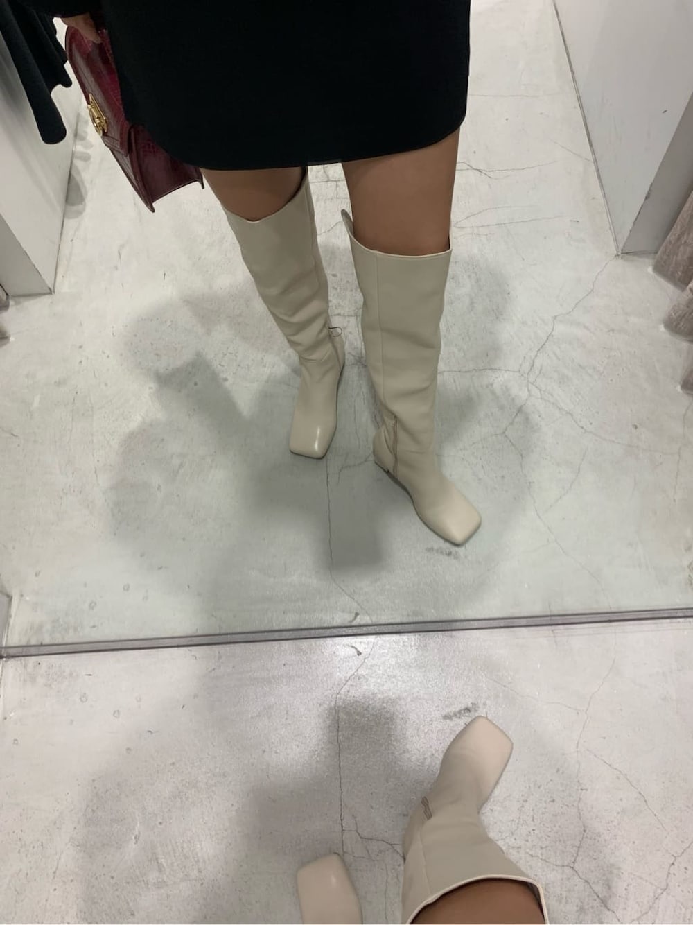 ブラック系のテーラードジャケット、ブラック系のスカート、ホワイト系のブーツを着用したレディースの秋コーディネートの9枚目の写真