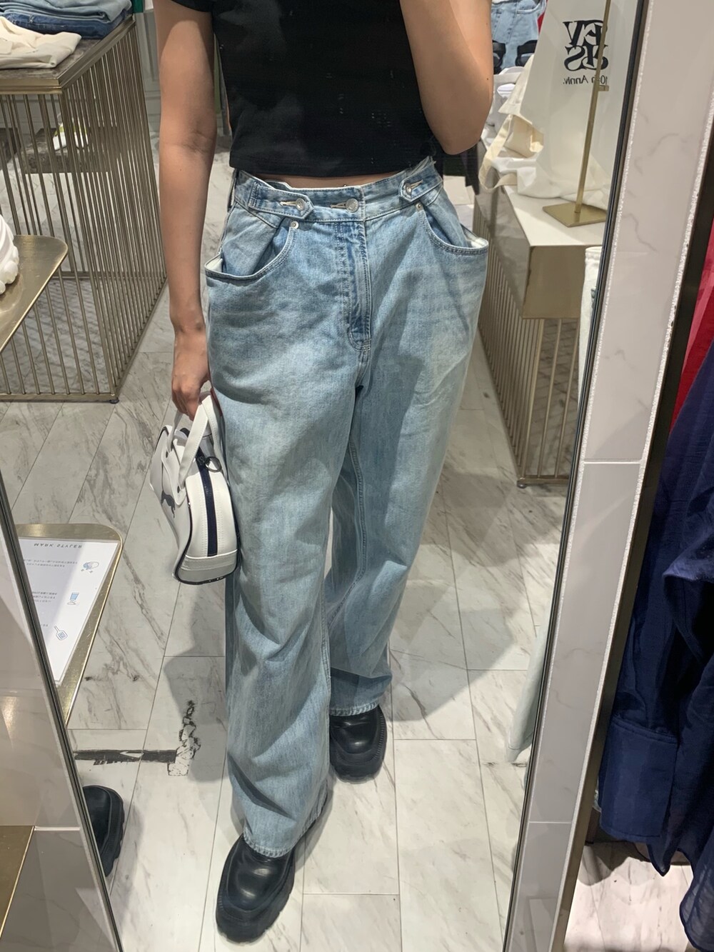 ブラック系のTシャツ/カットソー、ブルー系のデニムパンツ、ブラック系のブーツを着用したレディースの春コーディネートの5枚目の写真