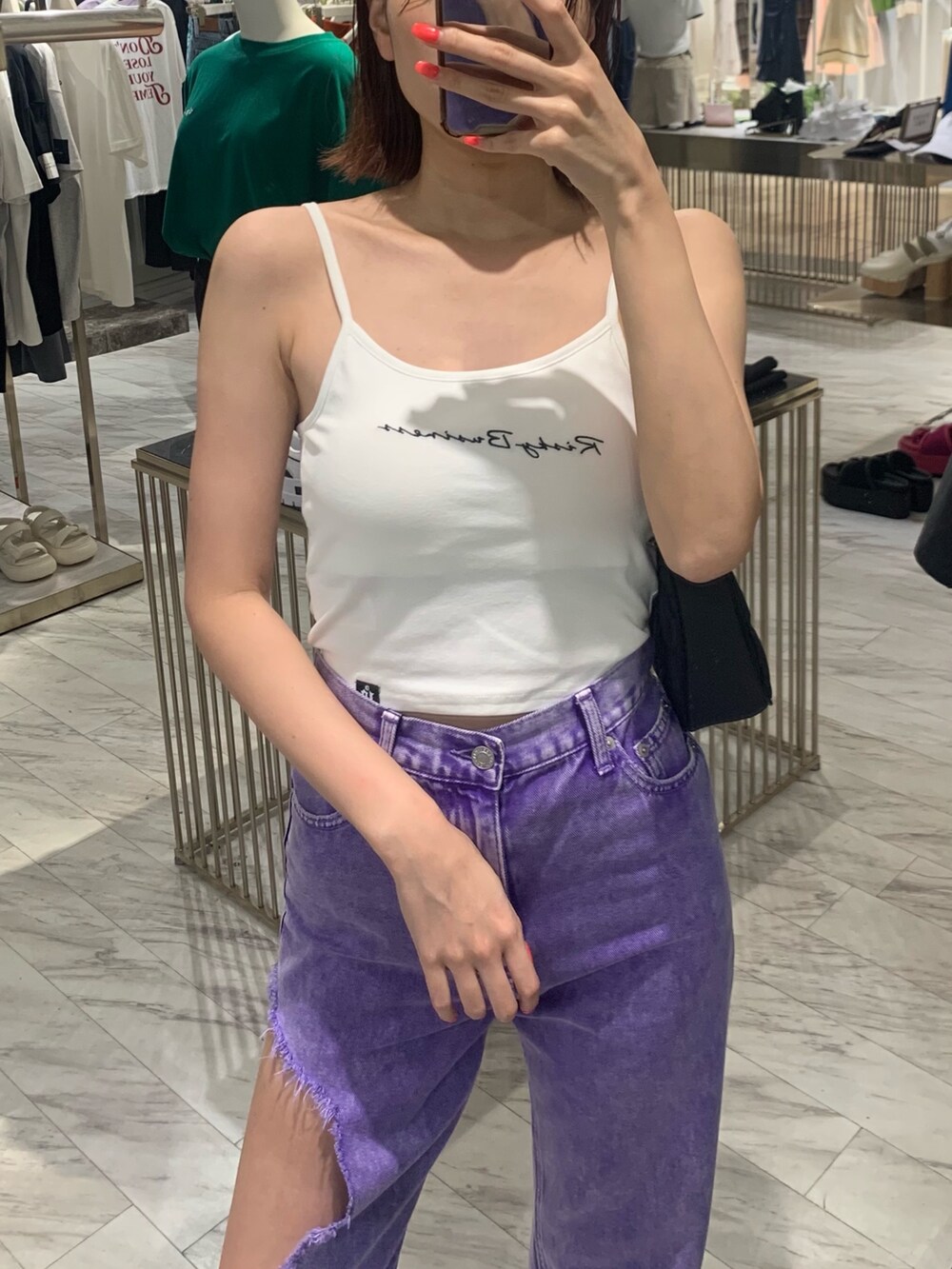 ホワイト系のキャミソール、パープル系のデニムパンツ、ブラック系のサンダルを着用したレディースの夏コーディネートの3枚目の写真