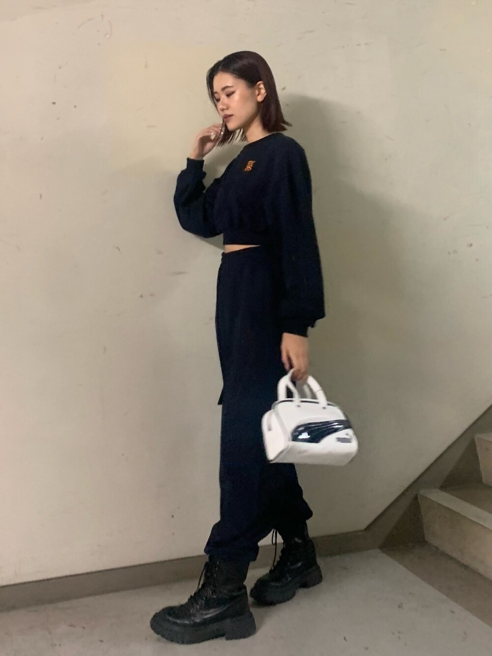 ブルー系のスウェット、ブルー系のスウェットパンツ、ホワイト系のハンドバッグを着用したレディースの秋コーディネートの2枚目の写真