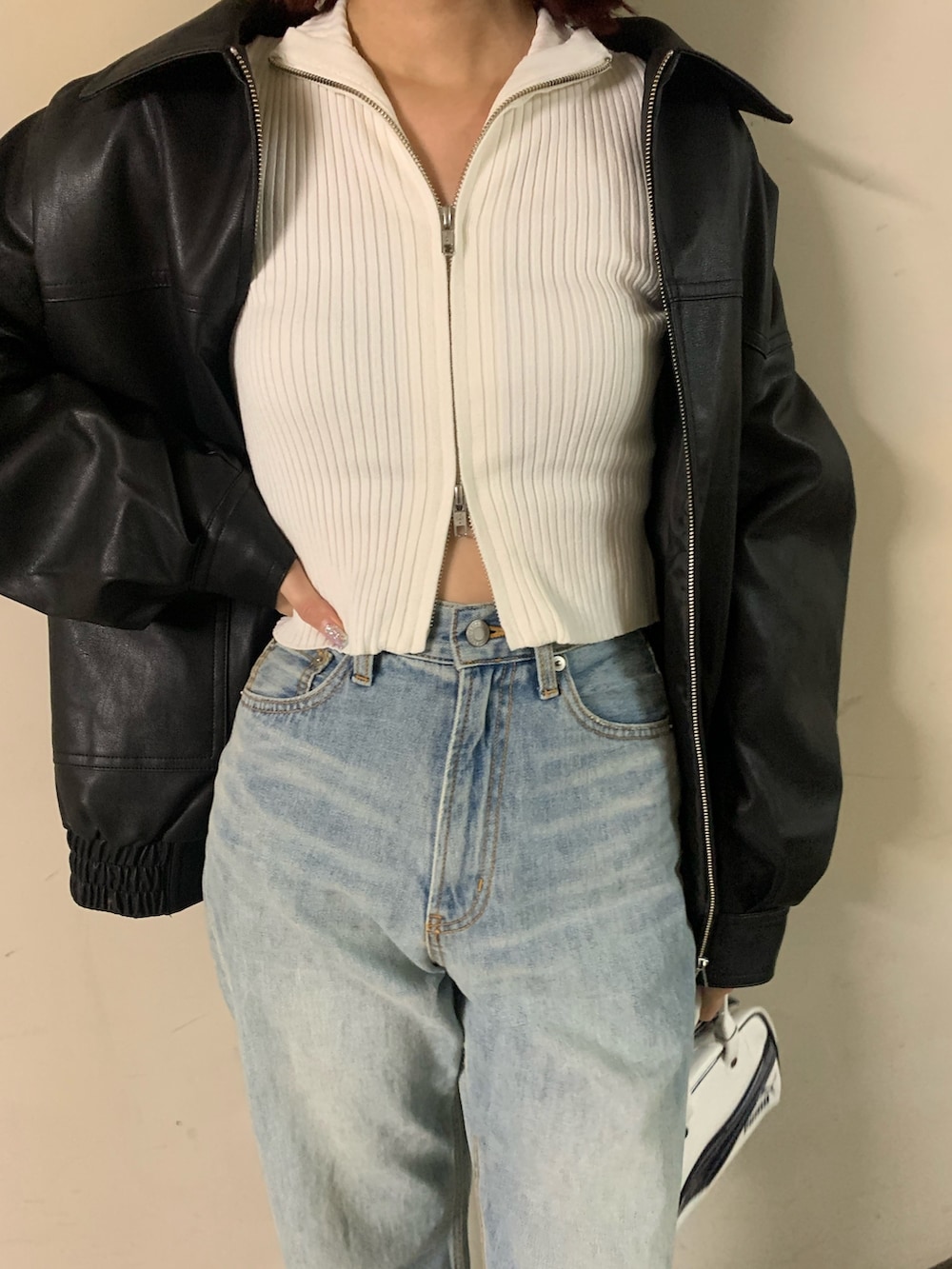 ホワイト系のニット/セーター、ブラック系のブルゾン、ブルー系のデニムパンツを着用したレディースの秋コーディネートの5枚目の写真