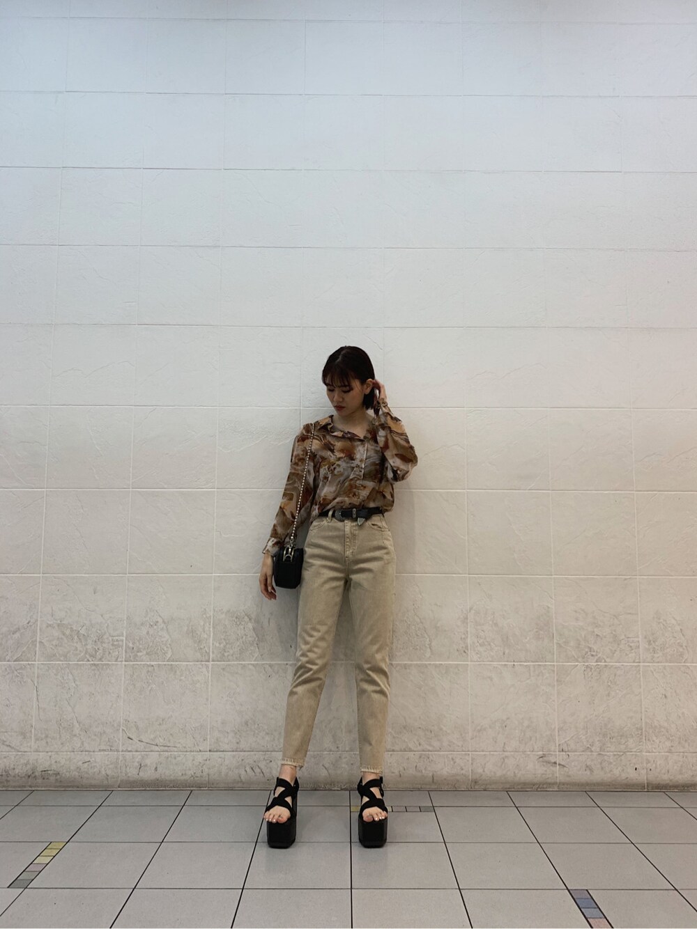 ブラウン系のキャミソール、ブラック系のサンダル、ベージュ系のデニムパンツを着用したレディースの春コーディネートの3枚目の写真