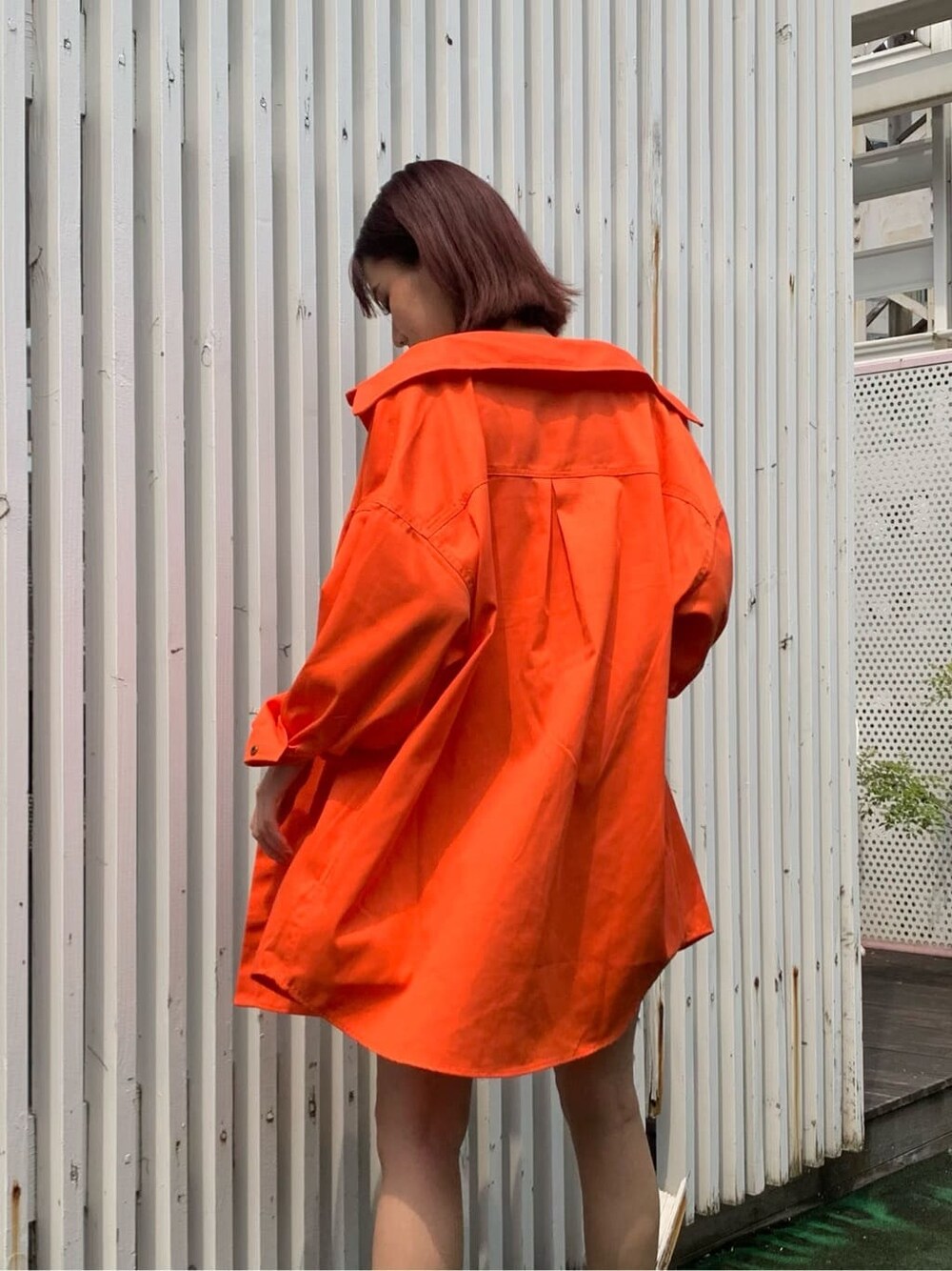 ブラック系のブーツ、ベージュ系のデニムスカート、オレンジ系のシャツ/ブラウスを着用したレディースの夏コーディネートの5枚目の写真