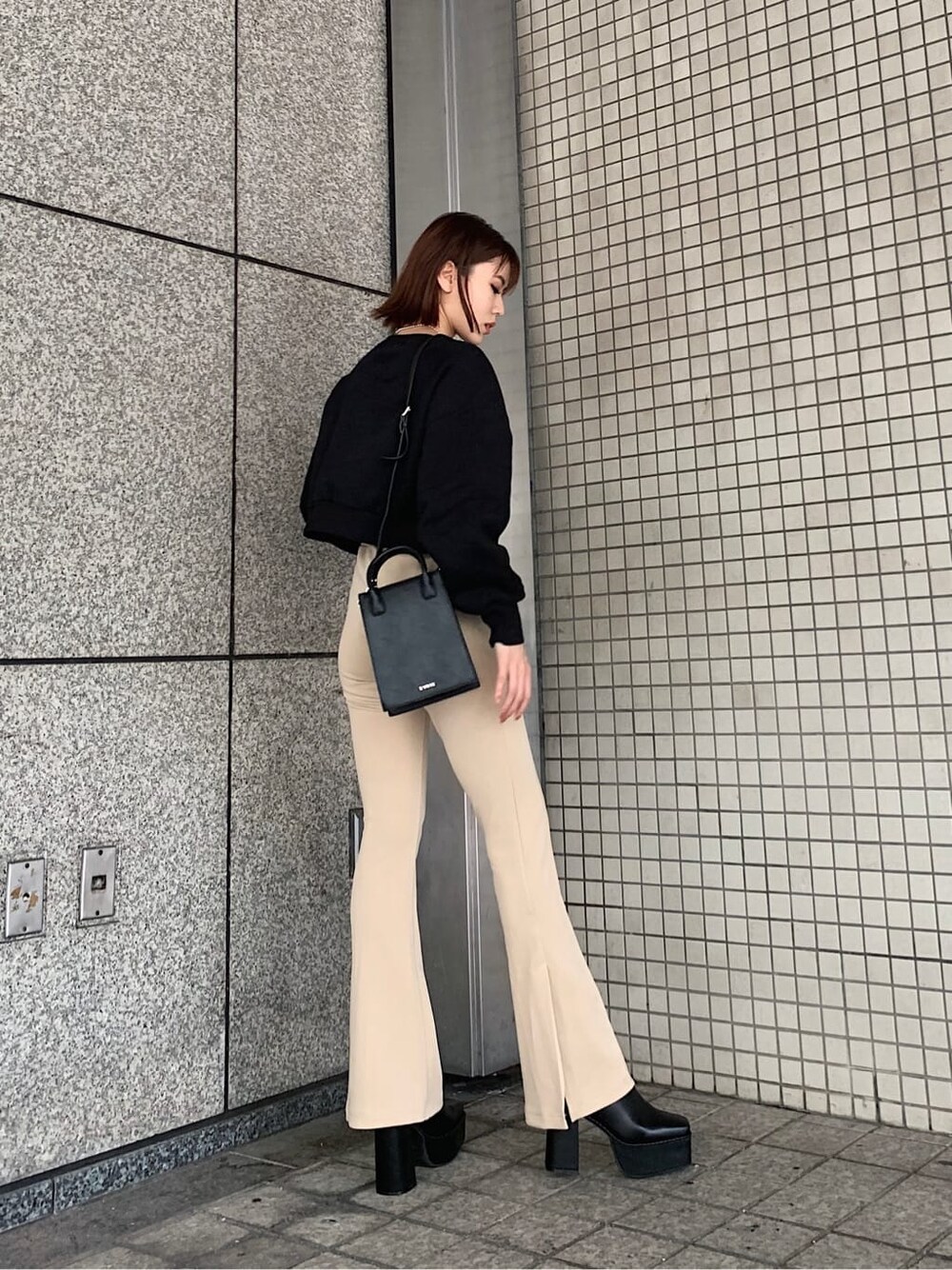 ブラック系のブーツ、ホワイト系のその他パンツ、ブラック系のショルダーバッグを着用したレディースの秋コーディネートの2枚目の写真