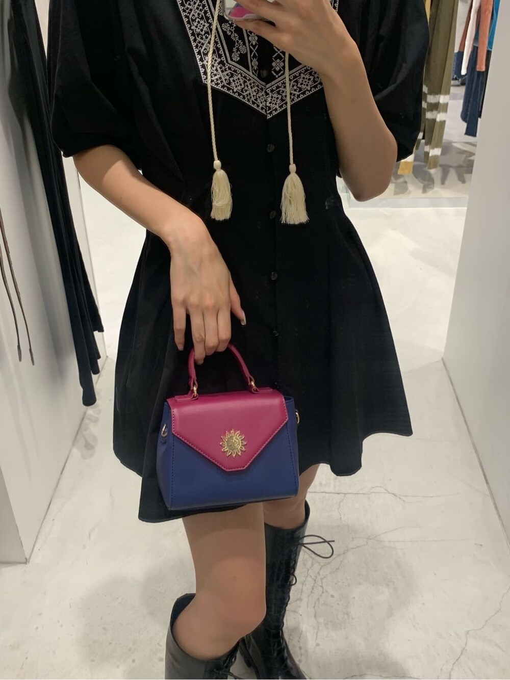 ブラック系のワンピース、ブラック系のブーツ、ブルー系のショルダーバッグを着用したレディースの夏コーディネートの5枚目の写真