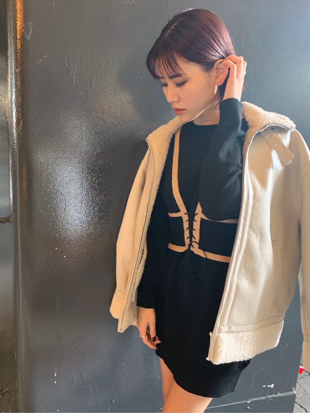 ホワイト系のブルゾン、ブラック系のブーツ、ゴールド系のリングを着用したレディースの冬コーディネートの2枚目の写真