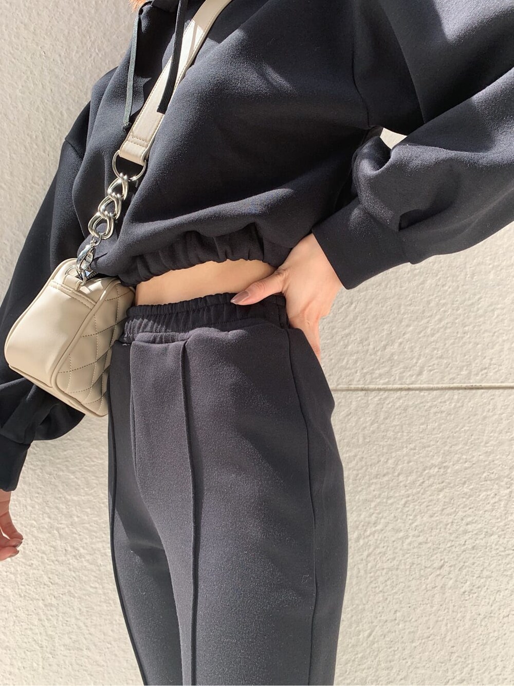 ブラック系のその他パンツ、ホワイト系のショルダーバッグ、ブラック系のパーカーを着用したレディースの秋コーディネートの3枚目の写真