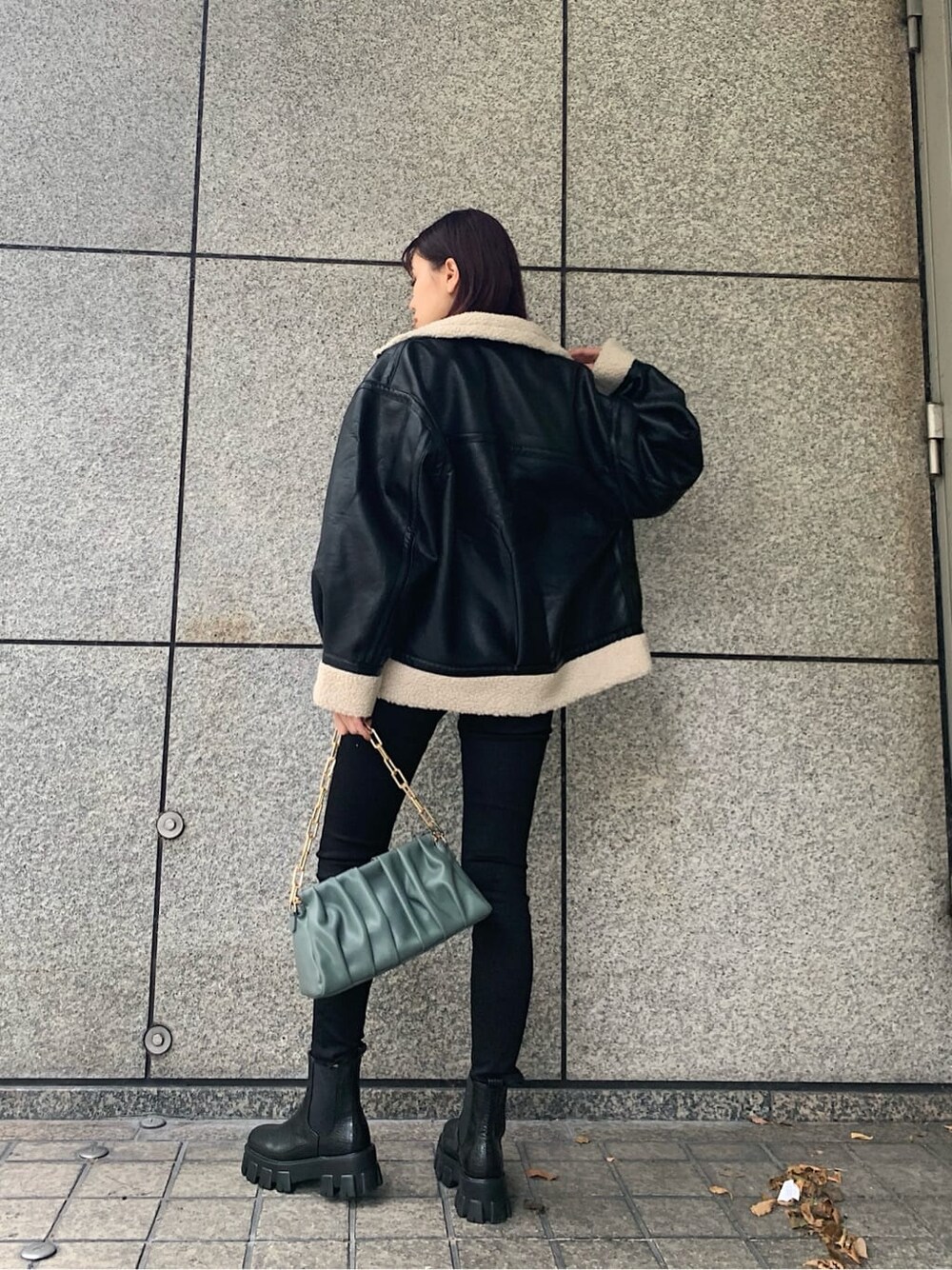 ブラック系のデニムパンツ、ブラック系のブルゾン、その他のブーツを着用したレディースの冬コーディネートの2枚目の写真