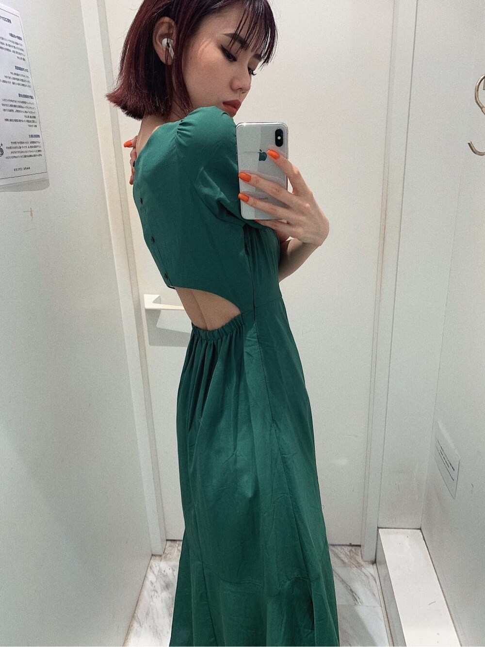 ブラック系のブーツ、ブラック系のショルダーバッグ、グリーン系のワンピースを着用したレディースの春コーディネートの4枚目の写真