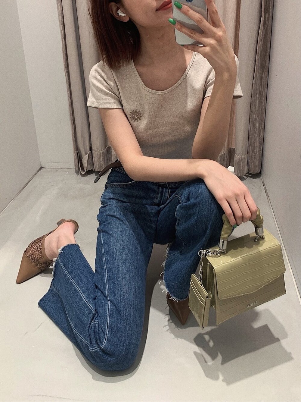 ブラウン系のパンプス、ブルー系のデニムパンツ、ベージュ系のTシャツ/カットソーを着用したレディースの春コーディネートの2枚目の写真