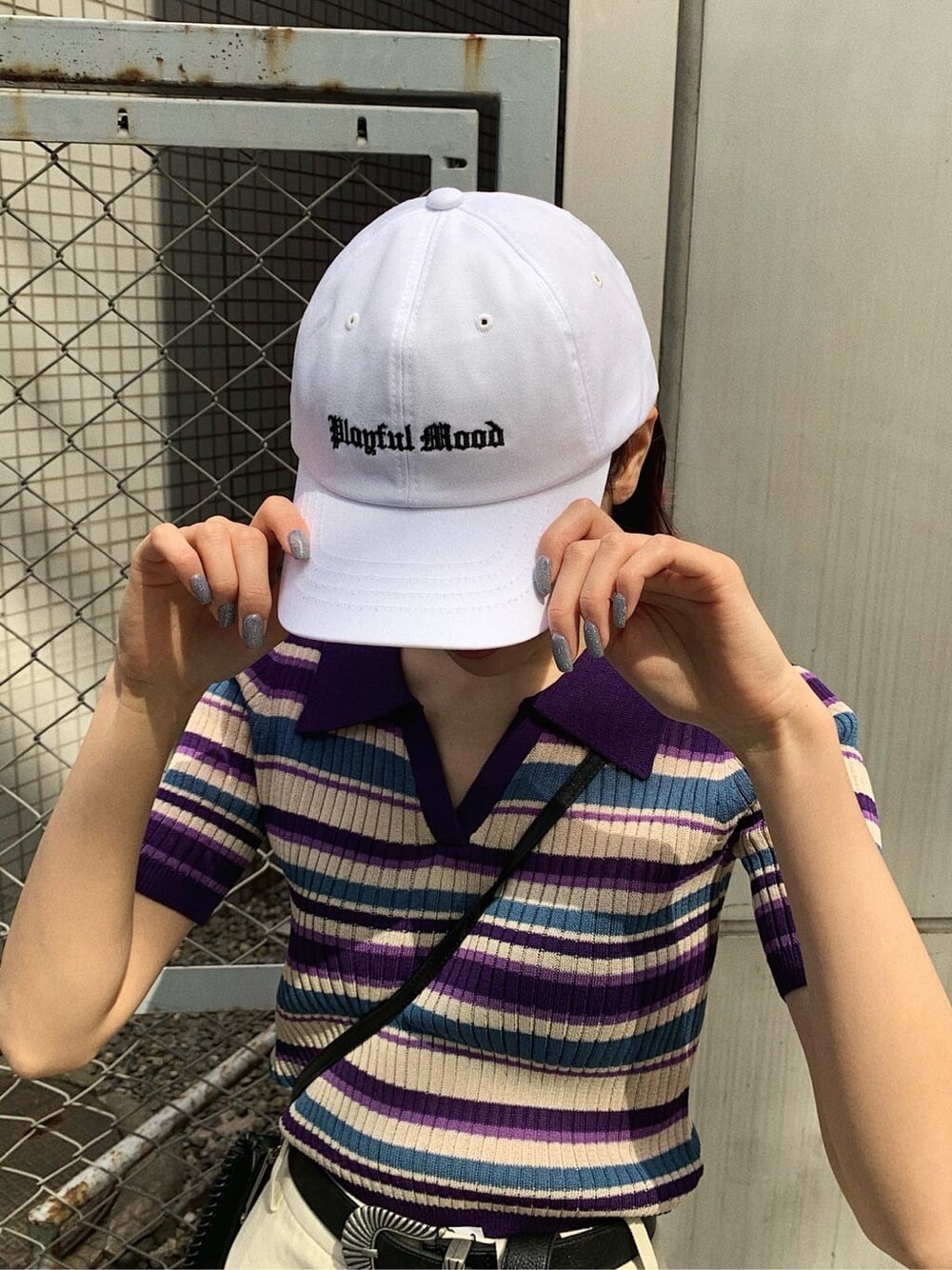 ブラック系のショルダーバッグ、ホワイト系のスカート、パープル系のニット/セーターを着用したレディースの春コーディネートの8枚目の写真