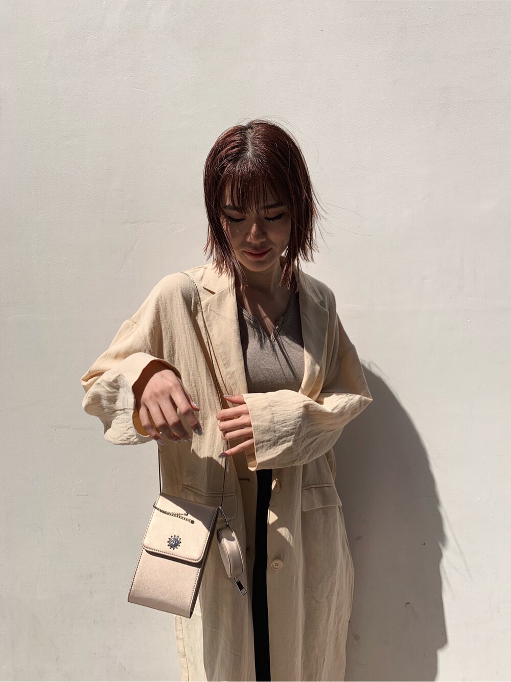 ベージュ系のチェスターコート、ブラック系のその他パンツ、ブラウン系のサンダルを着用したレディースの春コーディネートの4枚目の写真