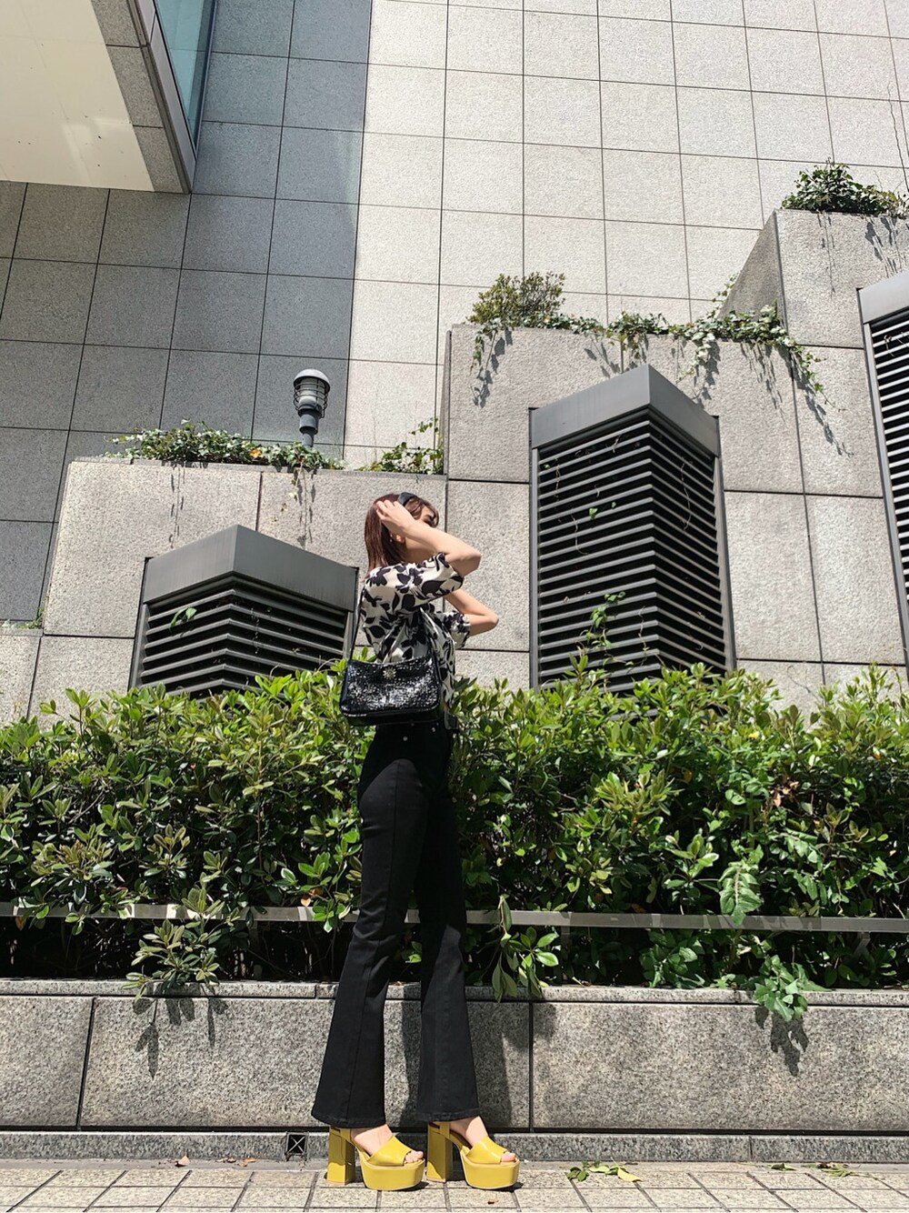 ホワイト系のシャツ/ブラウス、イエロー系のサンダル、ブラック系のショルダーバッグを着用したレディースの春コーディネートの2枚目の写真