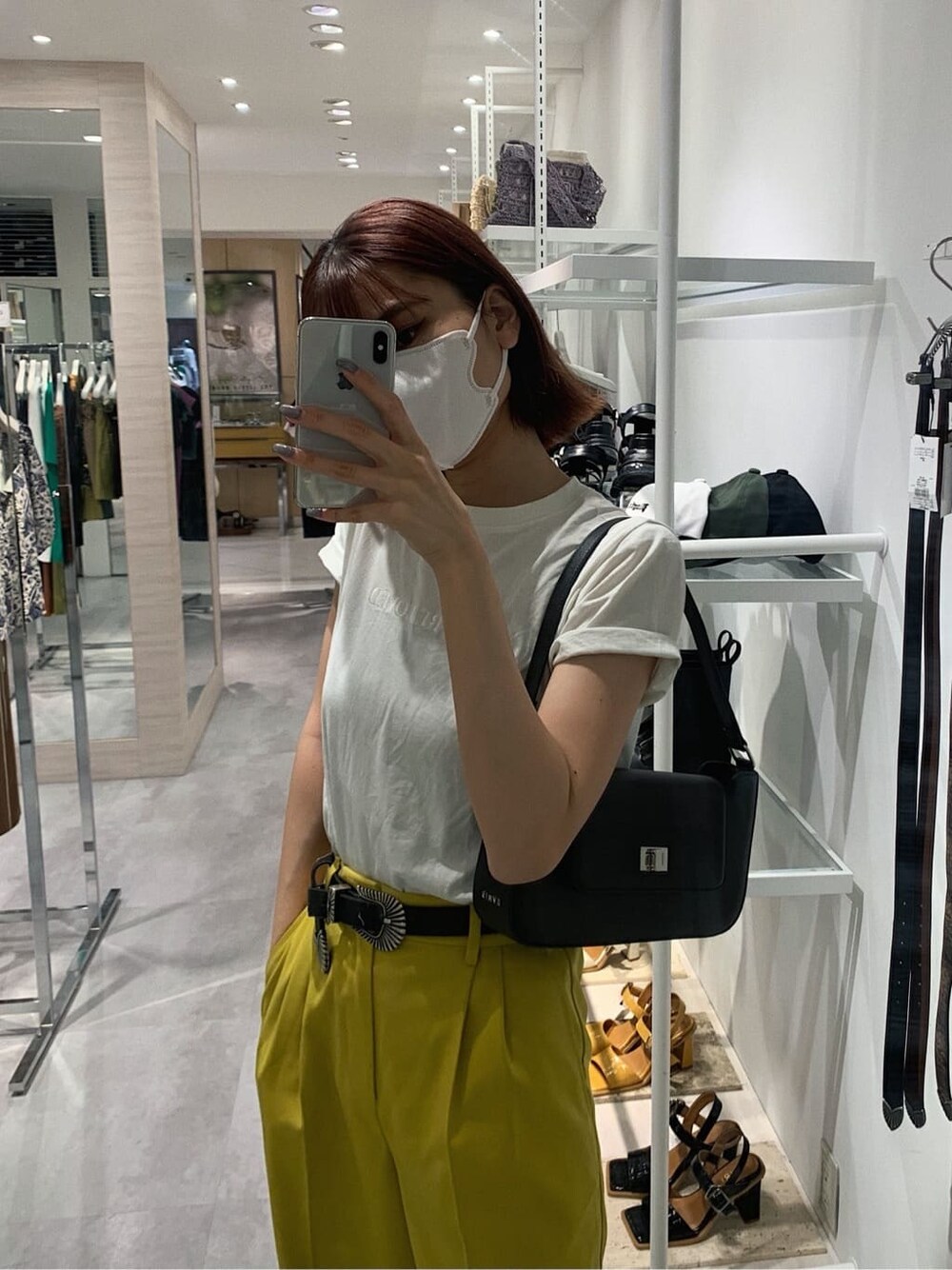 イエロー系のスラックス、ホワイト系のTシャツ/カットソー、ブラック系のブーツを着用したレディースの春コーディネートの7枚目の写真