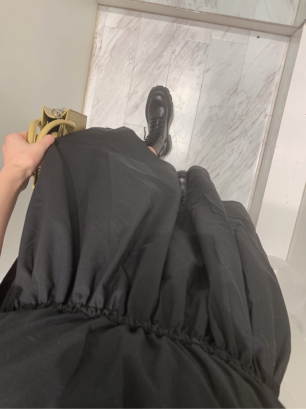 ブラック系のブーツ、イエロー系のショルダーバッグ、ブラック系のワンピースを着用したレディースの春コーディネートの6枚目の写真