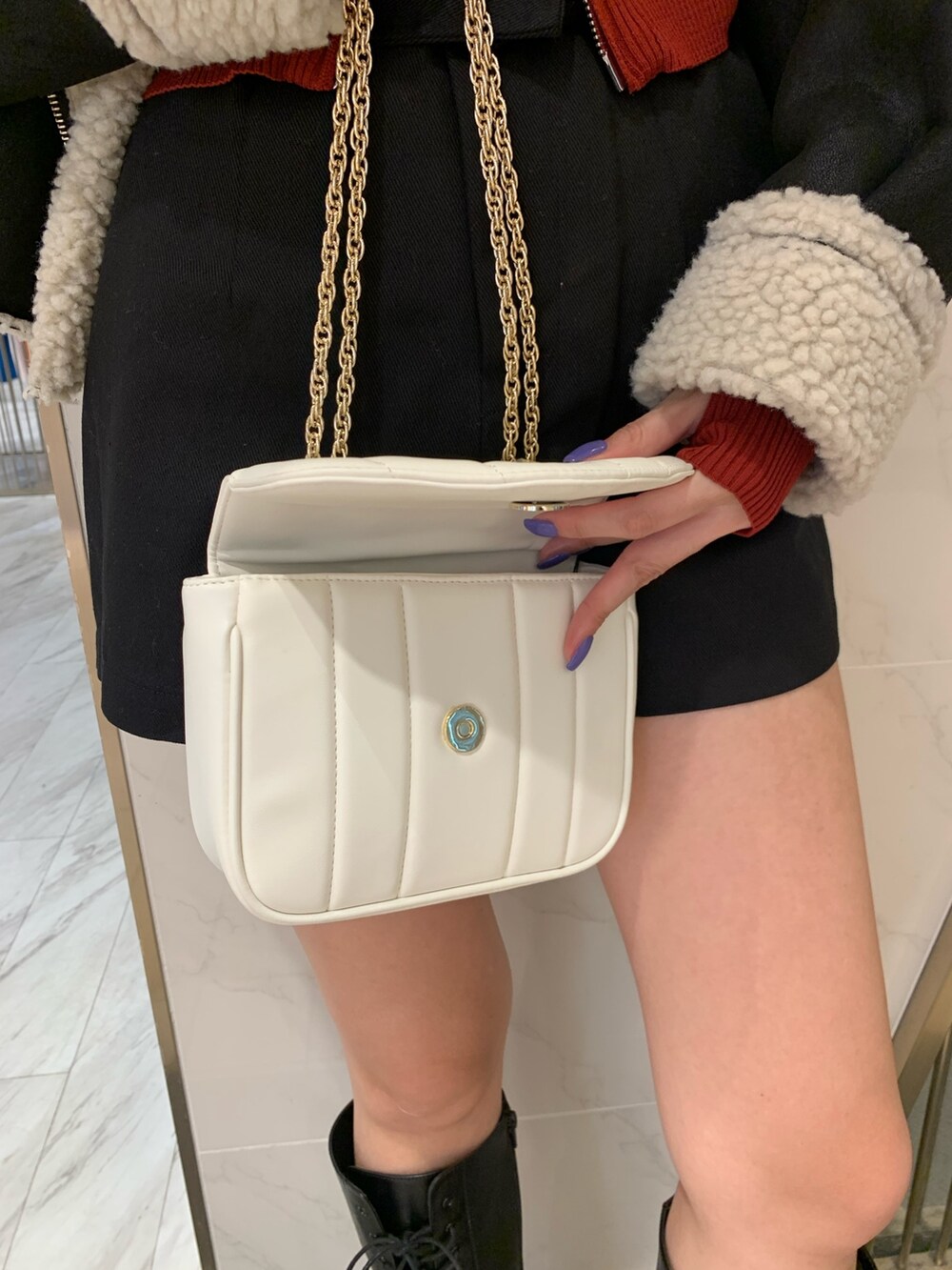 レッド系のニット/セーター、ブラック系のムートンコート、ブラック系のその他パンツを着用したレディースの夏コーディネートの7枚目の写真