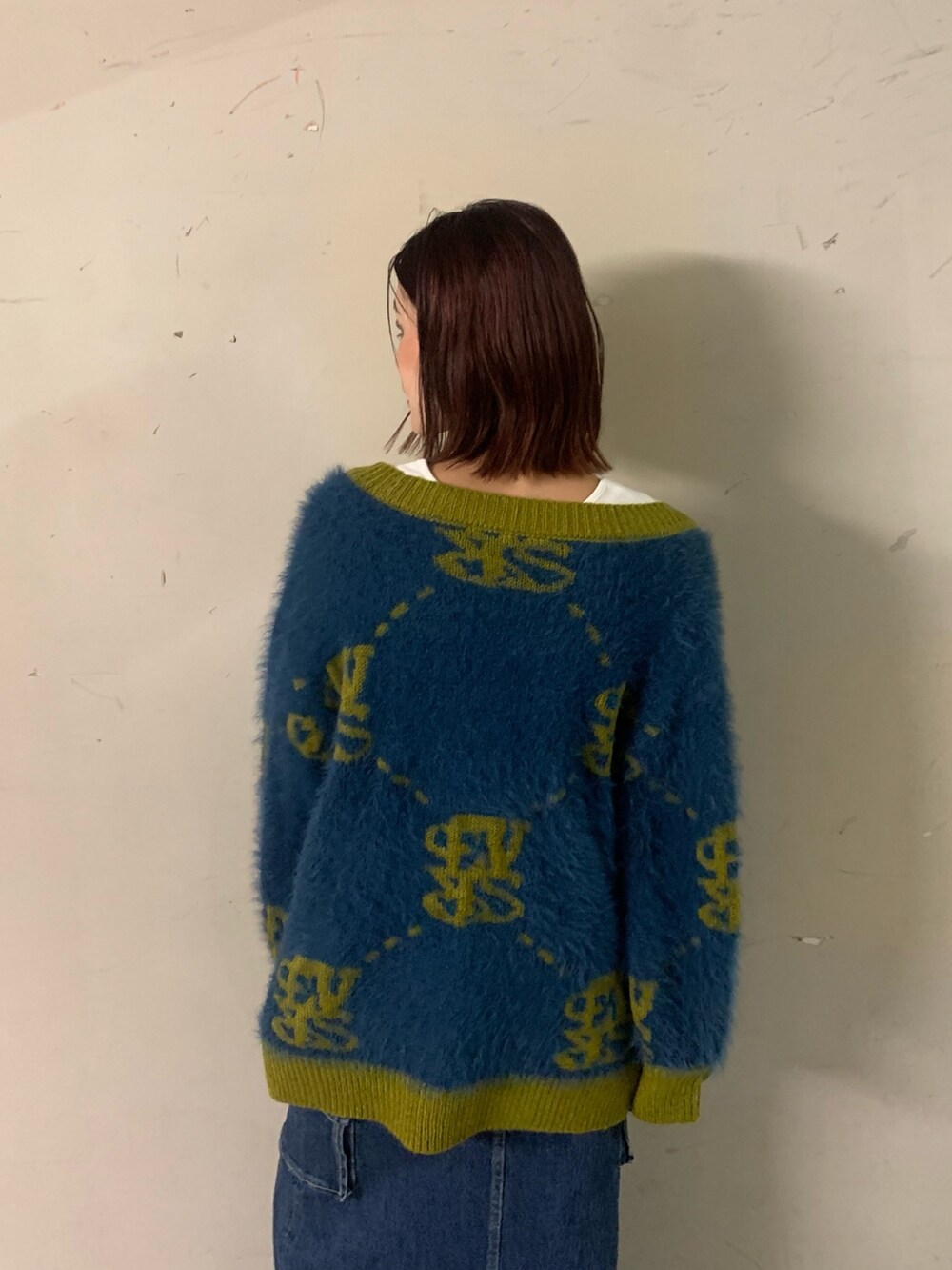 ブルー系のデニムスカート、ブルー系のカーディガン/ボレロ、ホワイト系のTシャツ/カットソーを着用したレディースの秋コーディネートの4枚目の写真