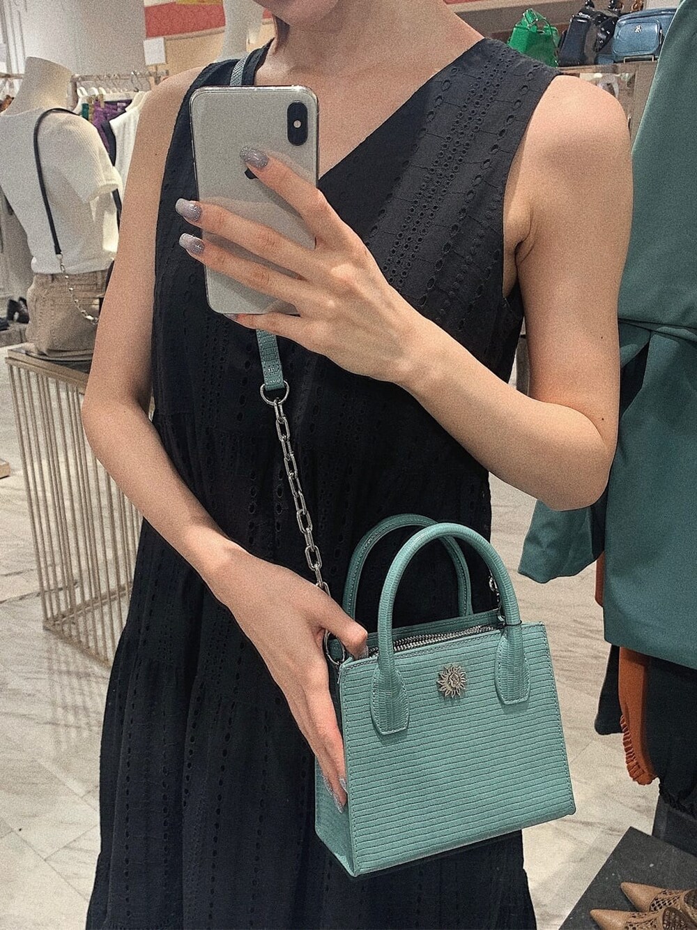 ブラック系のサンダル、ブラック系のワンピース、ブルー系のショルダーバッグを着用したレディースの春コーディネートの6枚目の写真