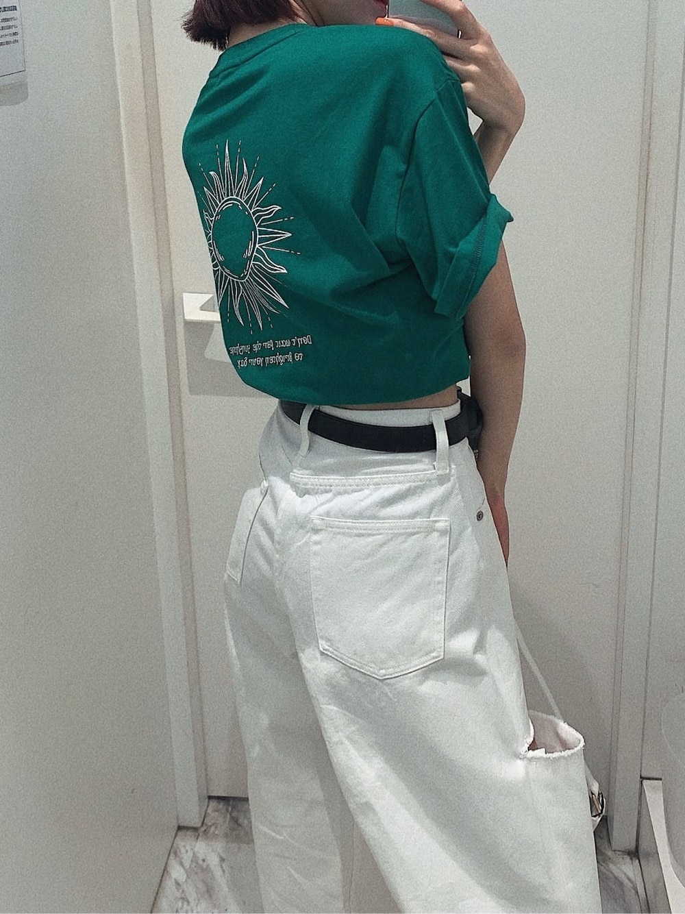 ブラック系のスニーカー、ホワイト系のショルダーバッグ、ホワイト系のデニムパンツを着用したレディースの春コーディネートの3枚目の写真