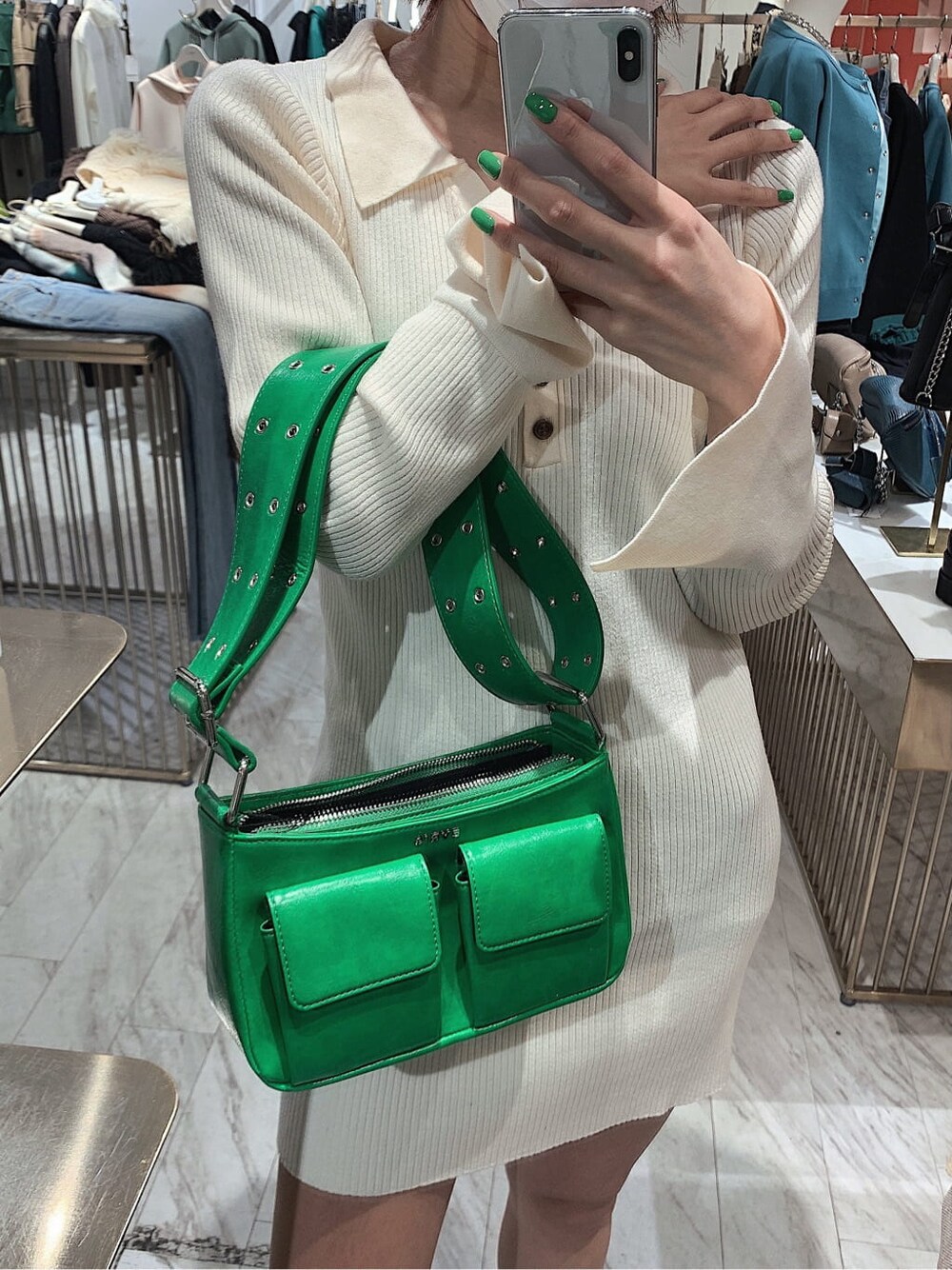 ホワイト系のワンピース、グリーン系のショルダーバッグ、ブラック系のブーツを着用したレディースの冬コーディネートの4枚目の写真